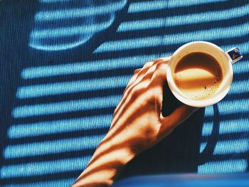 High angle view of hand holding coffee cup