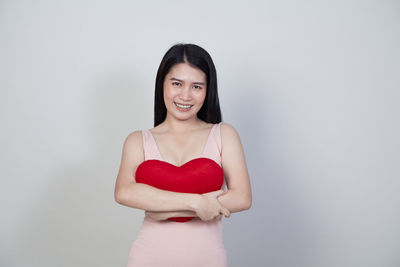 Portrait of a smiling young woman against white background