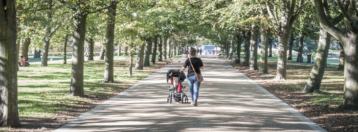 Rear view of people riding bicycle on road