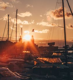 Silhouette boats sailing in sea against sky during sunset