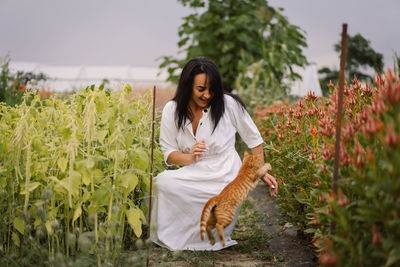 Portrait a woman stroking big red fluffy cat on nature. friendship people and animal.