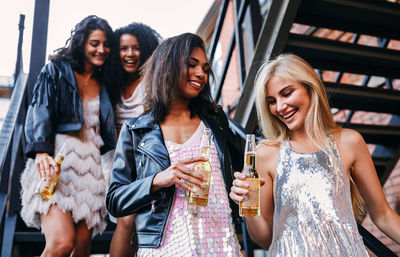 Happy friends holding beer bottle outdoor