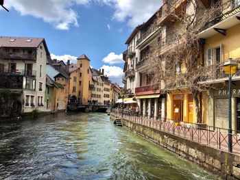 Canal amidst buildings in town against sky