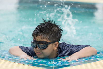 Boy happy swimming in a pool. children swimming and playing in water.