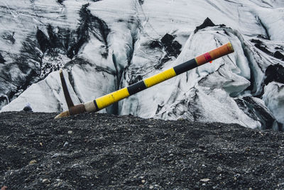 Pick axe on field against glacier