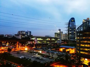 Illuminated city against sky at night