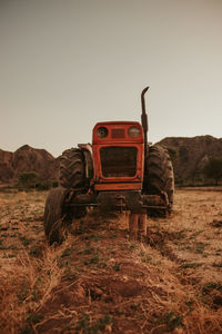 Abandoned truck on field against clear sky