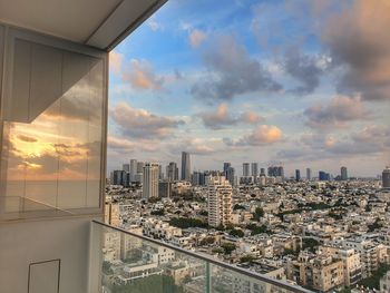Modern buildings in city against sky during sunset