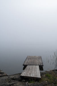 Lifeguard hut by lake against sky