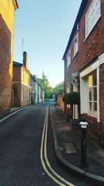 Empty road along buildings