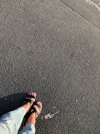 Low section of woman standing on road