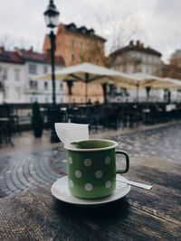 Green polka dot tea cup, empty city street.