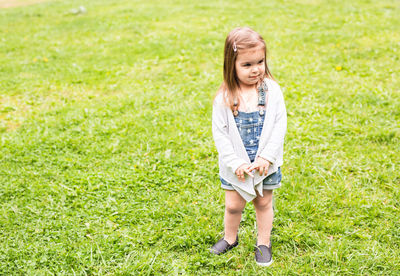 Full length of smiling girl standing on grass