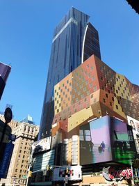 Low angle view of modern buildings against clear blue sky