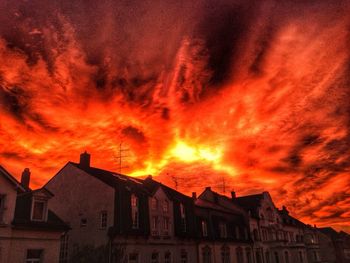 Silhouette of built structure against cloudy sky at sunset