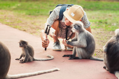 Man taking selfie with monkey outdoors