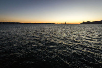 Scenic view of sea against clear sky at sunset