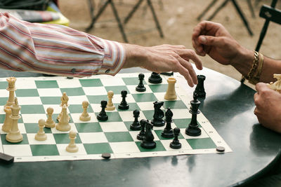 Cropped of friends playing chess on table