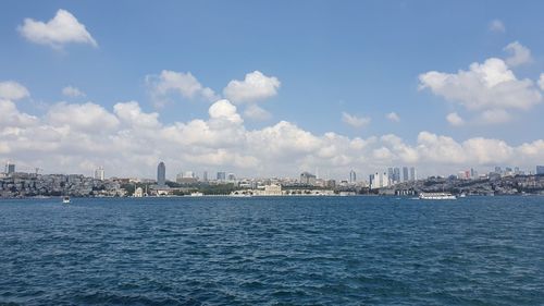 Scenic view of sea by buildings against sky