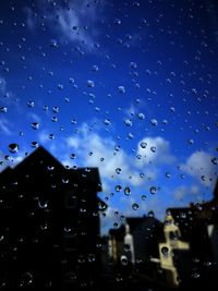 Close-up of wet windshield against sky