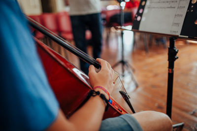 Midsection of man playing cello