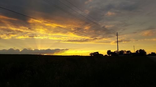 Scenic view of silhouette field against sky during sunset