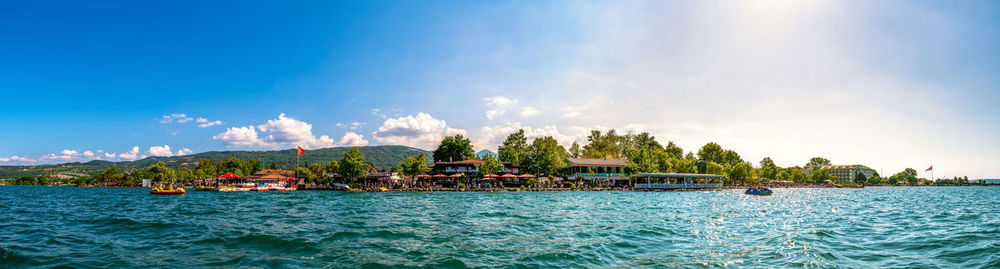 Panoramic view of sea against building and blue sky