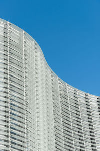 Low angle view of modern building against clear blue sky