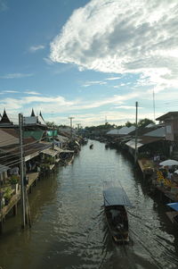 Boats moored at harbor against sky