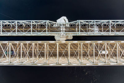 Low angle view of bridge against building at night
