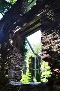 Low angle view of bridge over rocks in forest