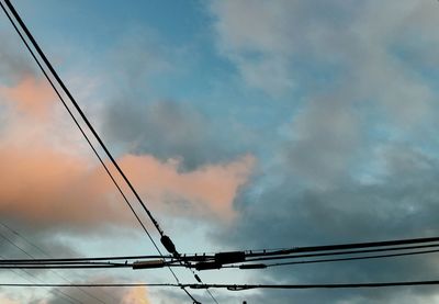 Low angle view of silhouette electricity pylon against sky