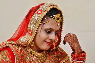 Close-up of bride wearing red sari by wall