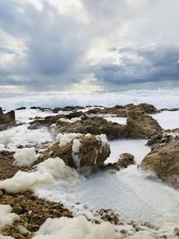 Rocks on beach against sky