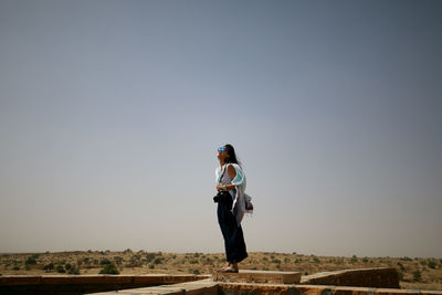 Full length of woman standing against clear sky