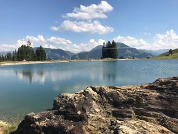 Scenic view of lake by mountain against sky