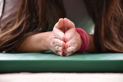 Woman meditating on exercise mat at home