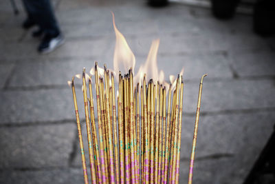 Close-up of lit candles in temple against building