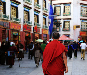 Rear view of monk walking in city