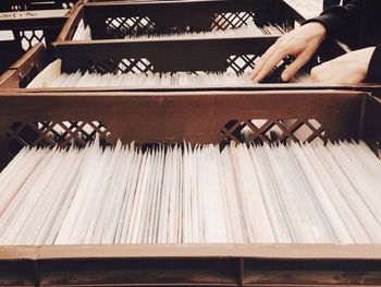 Cropped image of woman selecting file from shelf in office