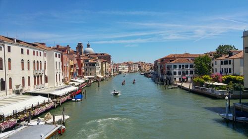 Boats in canal along built structures