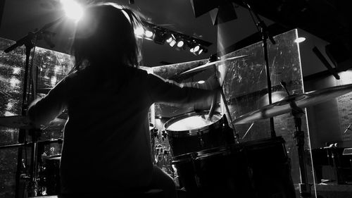 Rear view of woman playing at music concert