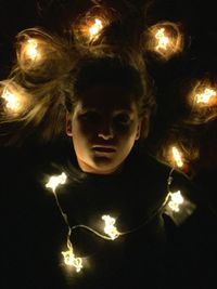 Portrait of woman with illuminated christmas lights