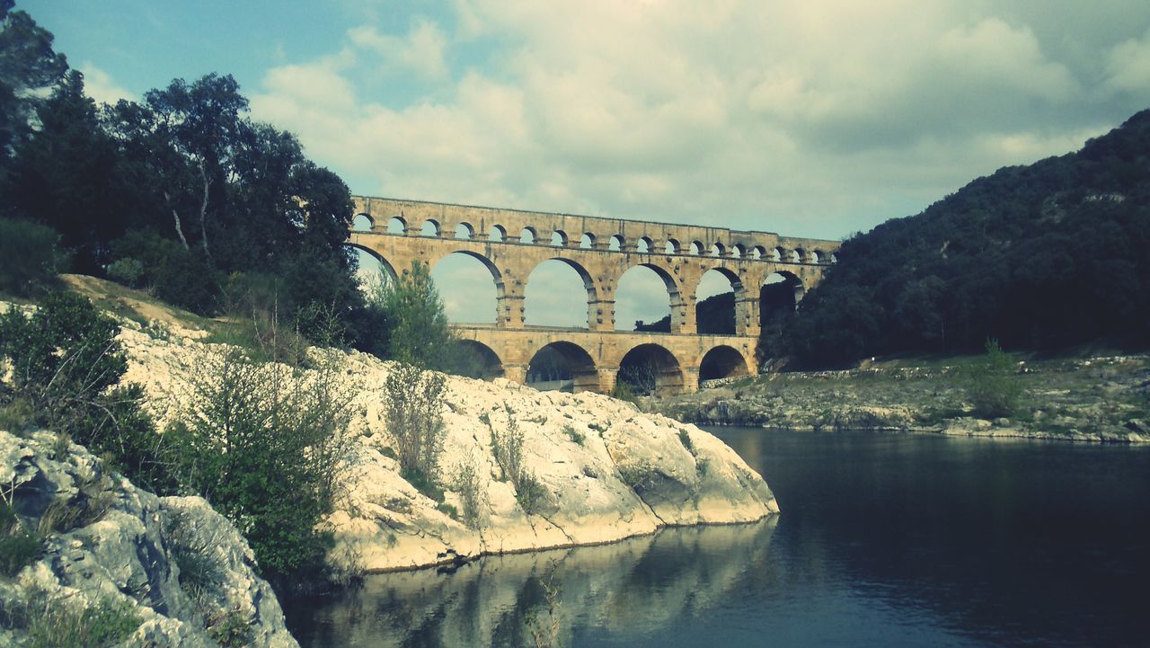 built structure, architecture, water, bridge - man made structure, connection, river, sky, waterfront, arch bridge, bridge, arch, tranquility, cloud - sky, reflection, tree, tranquil scene, nature, scenics, rock - object, travel destinations