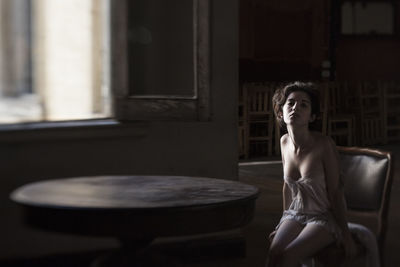 Young woman sitting on table