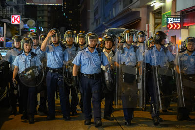 Group of people standing in city at night