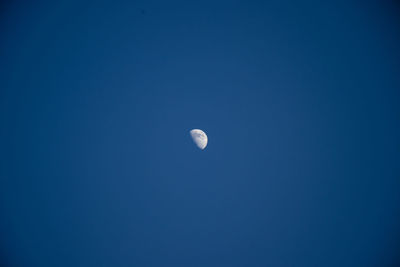 Low angle view of moon against blue sky