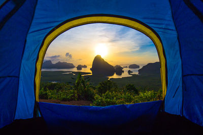 Scenic view of sunset seen through tent