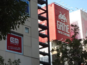 Low angle view of road sign against trees in city