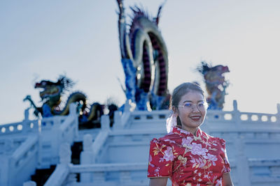 Portrait of young woman standing against sea